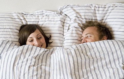 happy-couple-in-bed-undercovers-crop